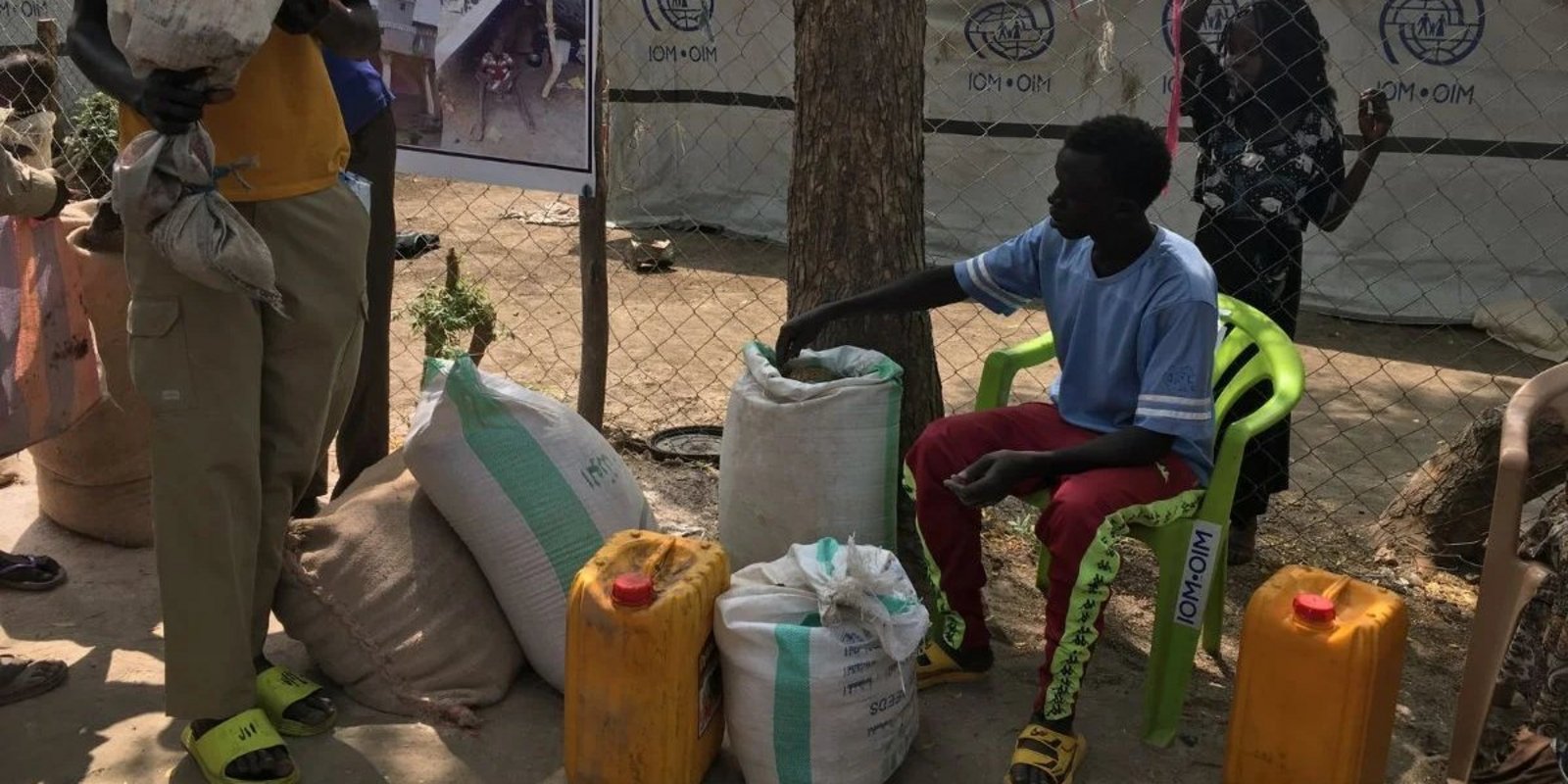 Menschen bei einer Lebensmittelausgabe auf staubigem Boden im Südsudan