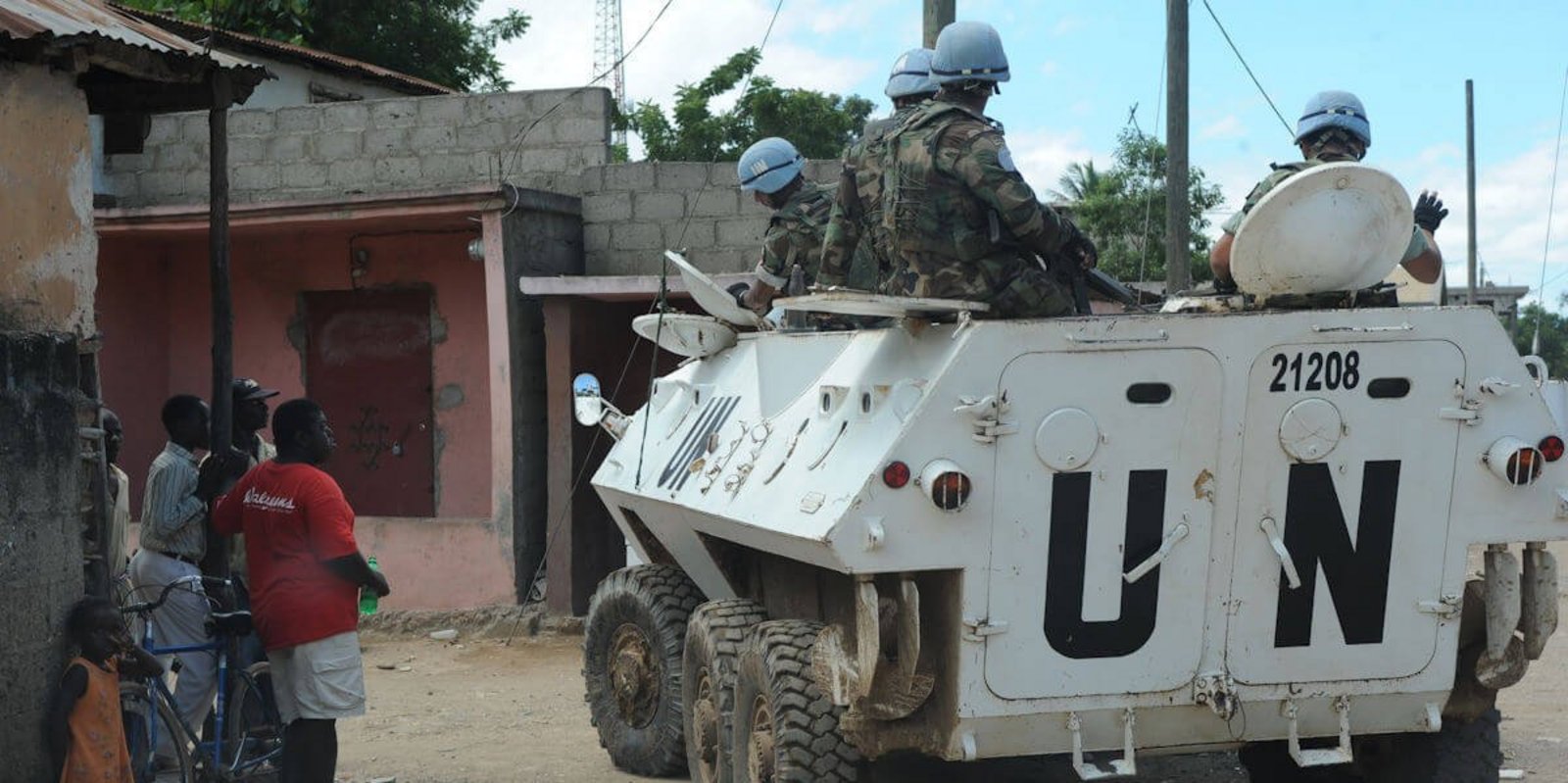 UN Panzer mit Soldaten fahren an Einheimischen vorbei